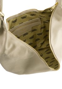 Beige Lederhandtasche mit strukturiertem Außenmaterial, goldenem Reißverschluss und stoffgefüttertem Innenraum mit einem wiederholten Logo-Muster. Inklusive Innenzippertasche.