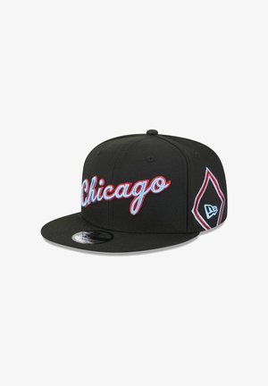 Schwarze Snapback-Kappe mit roter, kursiver "Chicago"-Stickerei auf der Vorderseite und einem Diamant-Logo an der Seite. Glatte Stoffstruktur.