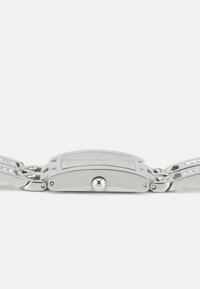 Silver metal watch with a rectangular case, rounded edges, and a polished finish. Features a minimalist design and a clasp bracelet.
