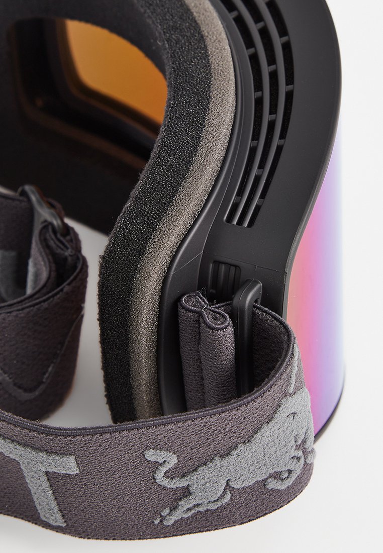 Schneebrille mit schimmernder Linse, schwarzem Schaumstoffpolster, Belüftungsöffnungen und einem elastischen Riemen mit einem grauen Leopardenmuster.