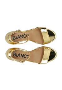 Sandali in pelle verniciata oro con una larga fascia anteriore, cinturino alla caviglia e punta arrotondata. Nome del marchio "BIANCO" visibile sulla soletta.