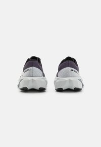 Purple and gray athletic shoes with a textured fabric upper, featuring a unique geometric sole design and logo detailing on the heel.