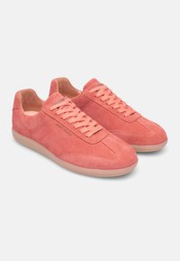 Pink suede sneakers with flat laces, rounded toes, textured upper, and rubber soles. Features minimal branding on the side.