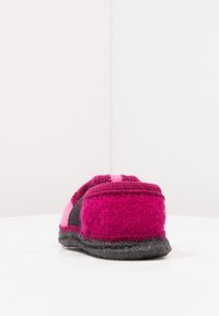 Vilt slipper in magenta en roze met een zwarte accent, met een zachte textuur, ronde vorm en gestikte details.