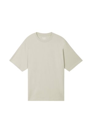 Camiseta de cuello redondo beige de manga corta y oversize con un ajuste relajado, exhibida sobre un fondo blanco.