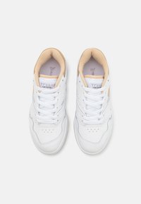 Baskets blanches en cuir avec une finition lisse, boîte à orteils perforée et accents en suède beige au niveau du talon. Fermeture à lacets et col rembourré.