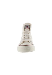 Beige hoge canvas sneaker met witte rubberen zool, rode streep en metalen veterogen. Voorzien van een logopatch op de tong.