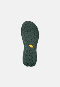 Suola di gomma verde con treads circolari, caratterizzata da un logo Vibram giallo prominente. Texture resistente progettata per trazione e aderenza.