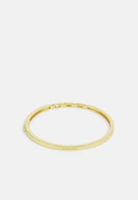 Auksinės spalvos bangles apyrankė su lygiu, plokščiu paviršiumi ir subtiliu logotipo graviravimu. Savybėje yra hinged uždarymas su mažais dekoratyviniais akcentais.