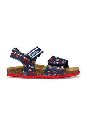 Sandalo Geox blu navy per bambini con suola rossa, sottopiede in sughero, cinturini regolabili e loghi Superman rossi e gialli.