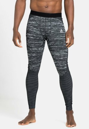 Black athletic leggings featuring a textured pattern with varying stripe widths and a black waistband with a logo detail.