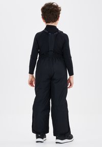 Zwarte sneeuwbroek met verstelbare bandjes, elastische tailleband en wijde pijpen. Gemaakt van een duurzaam materiaal en voorzien van subtiele stikseldetails.