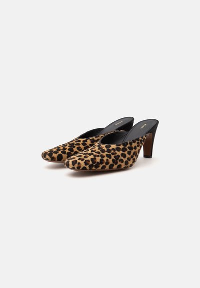 Paire de mules à bout pointu avec imprimé léopard et intérieur noir, dotées de talons fins marron de hauteur moyenne sur fond blanc.