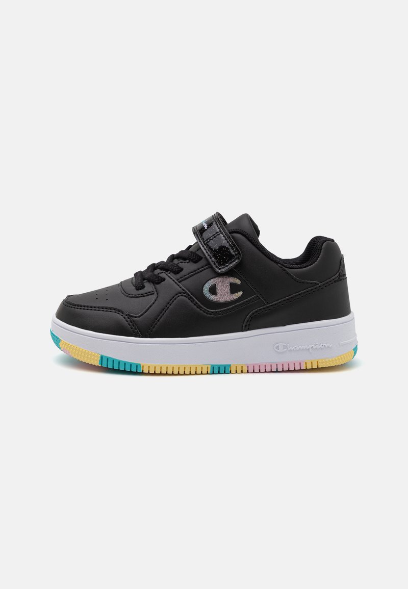 Black athletic shoes with a smooth leather upper, Velcro strap, and white midsole. Sole features a colorful, striped pattern in blue, pink, and yellow.