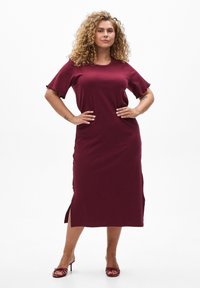 Robe bourgogne, mi-longue, avec des manches courtes et volantes, dotée d'une coupe décontractée et d fentes latérales. Texture lisse, design décontracté.