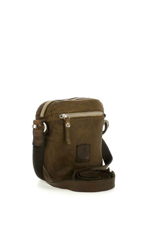 Piccola borsa a tracolla in pelle marrone con tasca frontale con cerniera e tracolla regolabile in tessuto arrotolata accanto.