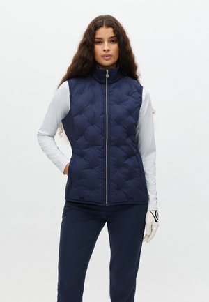 Gilet imbottito blu navy con motivo trapuntato, collo alto, cerniera frontale e due tasche laterali, abbinato a una maglia a maniche lunghe di colore grigio chiaro.