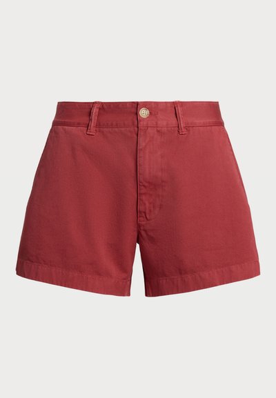 Calções de algodão vermelhos com corte reto, apresentando um fecho frontal com botão, passantes para cinto e uma bainha que cai logo acima do joelho.