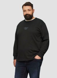 Zwarte lange mouwen T-shirt met een ronde hals en een subtiele blauwe logo op de borst. Zachte stof en losse pasvorm. Gecombineerd met donkere denim jeans.