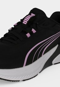 Ασπρο-μαύρο αθλητικό παπούτσι Puma με ροζ λεπτομέρειες, με χοντρή σόλα, κορδόνια μπροστά και λογότυπο Puma στη γλώσσα και στην πλευρά.