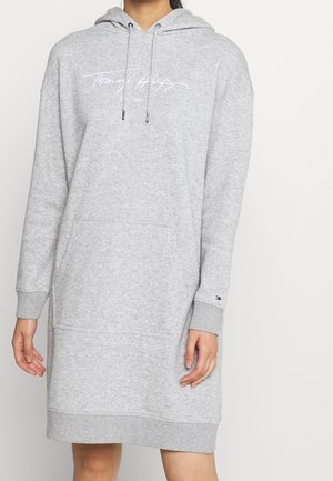 Grå hættetrøjekjole i bomuldsblanding med kængurulomme, ribbede manchetter og broderet logo foran. Blød tekstur, knælængde.