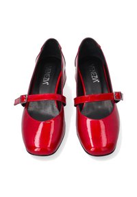 Rote Lackleder-Ballerinas mit runder Spitze, Knöchelriemen und einem leichten Absatz. Schwarze Innenauskleidung mit deutlich angezeigtem Markenlogo.