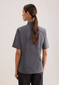 Camicia a maniche corte in tessuto grigio scuro con un delicato motivo a trama, caratterizzata da un colletto a punta e una vestibilità sagomata.