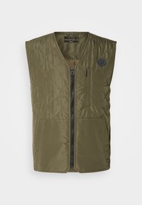 Gilet sans manches matelassé vert olive avec fermeture éclair à l'avant, poche poitrine zippée et deux poches avant inférieures, présenté sur fond blanc.