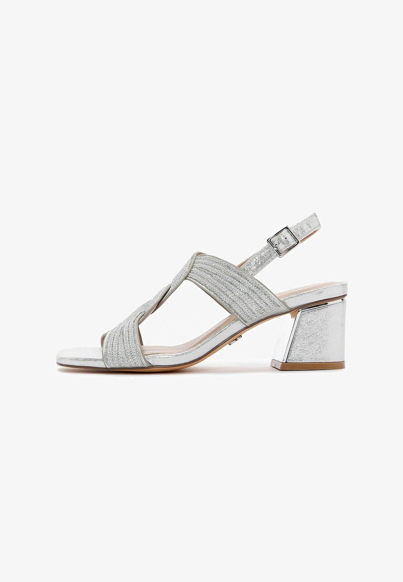 Sandale argentée à talons avec une tige texturée, design ouvert à l'avant et une sangle de cheville réglable. Présente un talon carré avec un accent métallique brillant.
