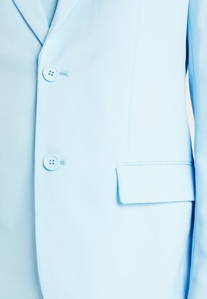 Svijetloplavi sako s dva zakopčana gumba i prednjim džepom s preklopom na desnoj strani.