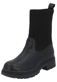 Czarny botek za kostkę z grubą gumową podeszwą. Posiada gładką skórzaną wkładkę oraz żebrowaną dzianinową cholewkę z geometrycznym wzorem.