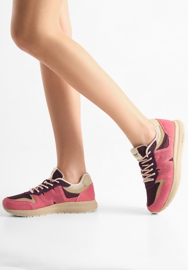 Roze en bordeauxkleurige sportsneakers van mesh en suède materialen, met crèmekleurige accenten en vetersluiting. Platte, patroonrubberen zool.