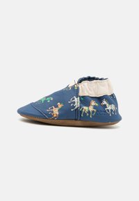 Chaussure en cuir bleu doux pour enfant ornée de motifs colorés de chevaux. Cheville élastiquée pour un bon maintien, avec une semelle en daim marron flexible.