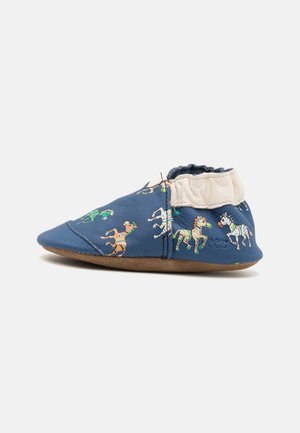 Chaussure en cuir bleu doux pour enfant ornée de motifs colorés de chevaux. Cheville élastiquée pour un bon maintien, avec une semelle en daim marron flexible.