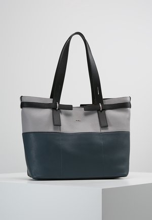 Two-tone leather tote bag in gray and dark blue with black double handles resting on a white pedestal against a plain background.