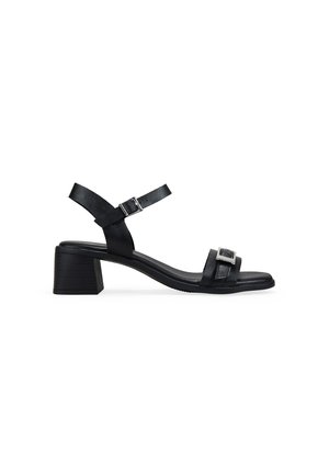 Sandalia de cuero negro con tacón de bloque de 5 cm, tira ajustable en el tobillo y detalle de hebilla en la tira del dedo, mostrada sobre fondo blanco.