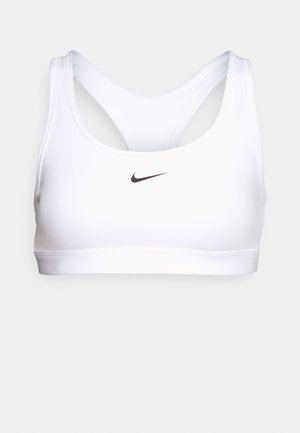 Reggiseno sportivo bianco con una texture liscia, dotato di spalline larghe e design racerback. Un piccolo logo Nike nero è centrato sulla parte anteriore.