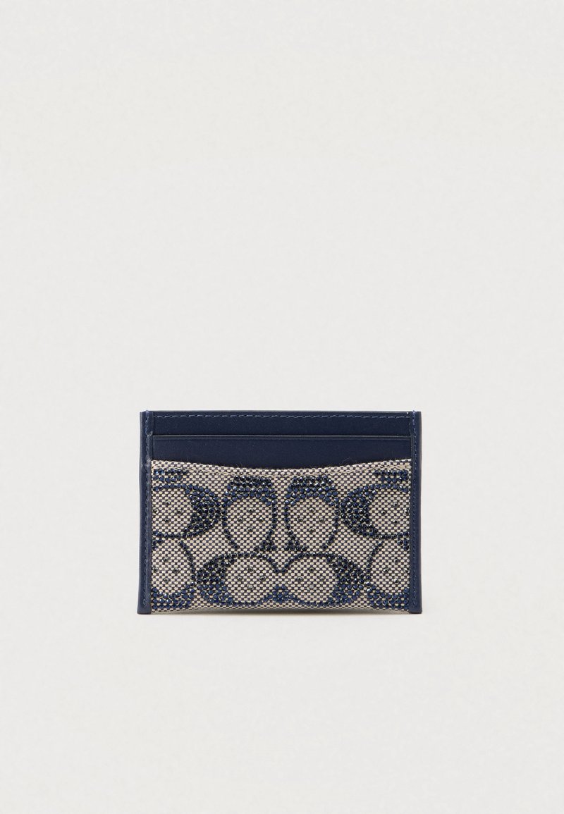 Καρτοθήκη σε ναυτικό μπλε χρώμα με υφαντό μοτίβο σε μπεζ αποχρώσεις και σκουρόχρωμες λεπτομέρειες. Περιλαμβάνει πολλαπλές θήκες για κάρτες και έχει κομψό, μινιμαλιστικό σχεδιασμό.