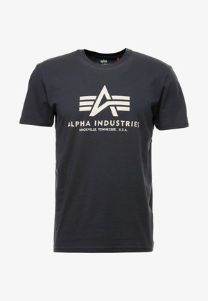 Mørkegrå bomulls t-skjorte med korte ermer. Har en stor hvit logo med tre striper og teksten "ALPHA INDUSTRIES, KNOXVILLE, TENNESSEE, U.S.A."