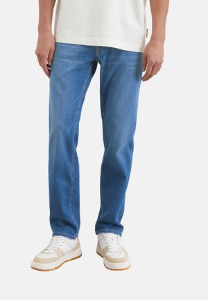 Light blue denim jeans with a straight cut, featuring five pockets and contrasting stitching. Paired with white sneakers with beige accents.