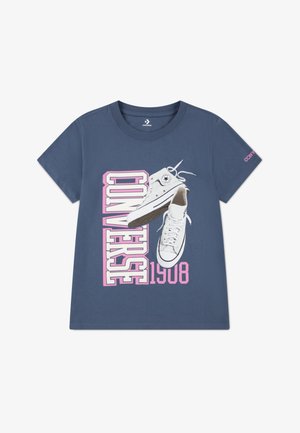 Navy blue cotton t-shirt featuring a graphic of white Converse sneakers and bold "CONVERSE 1908" text in pink and white. Short sleeves.