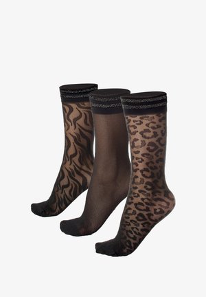 Tre paia di calze al ginocchio: una con stampa zebra, una nera uniforme e una con stampa leopardata, tutte con un elastico nero.