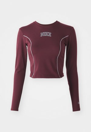 Crop top lungo marsala realizzato in tessuto elastico, con cuciture a contrasto bianche e logo Nike sul petto, dotato di maniche aderenti.