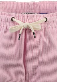 Pantalones cortos de pana rosa con una textura acanalada, una cintura con cordón y un lazo color crema, y detalles en negro en los ojetes.
