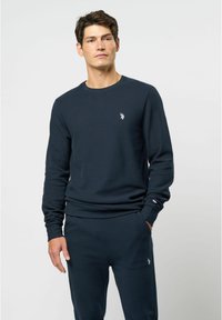 Marine crewneck sweatshirt gemaakt van textuurstof, met een klein geborduurd logo op de borst en geribbelde manchetten. Gecombineerd met bijpassende broek.