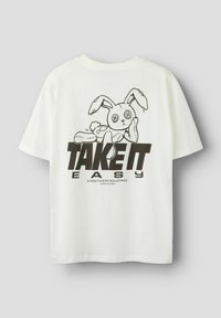 Biała bawełniana koszulka z czarną grafiką królika z guzikowymi oczami i napisem "ZRÓB TO NA LUŹNO" w pogrubionej czcionce.