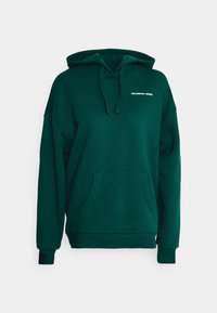 Sudadera con capucha de color verde oscuro, hecha de tela suave, que cuenta con un bolsillo tipo canguro, capucha con cordón y texto blanco "COLOURFUL REBEL" en el pecho.