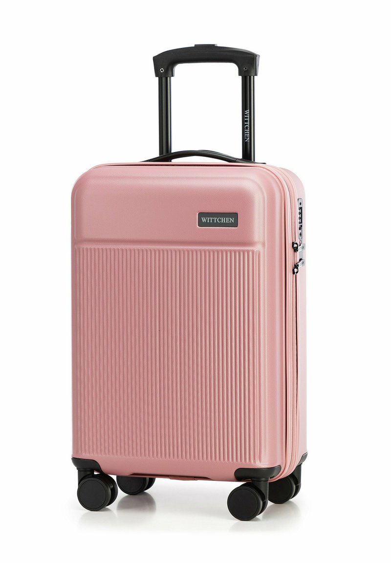 Růžový tvrdý kufr s vertikálním rýhováním, černými koly a vysouvací rukojetí. Na přední straně je viditelná značka.