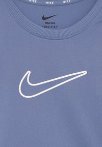 Koszulka Nike Dri-FIT w jasnoniebieskim kolorze. Okrągły dekolt z prążkowanym wzorem. Na przodzie znajduje się duże białe logo Nike w kształcie swooshu.