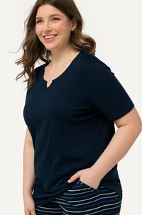 Námořnický modrý tričko s krátkým rukávem a jemným V-výstřihem, vyrobené z měkké látky. Doplněné pruhovanými pyžamovými kalhotami v odstínech modré a šedé.